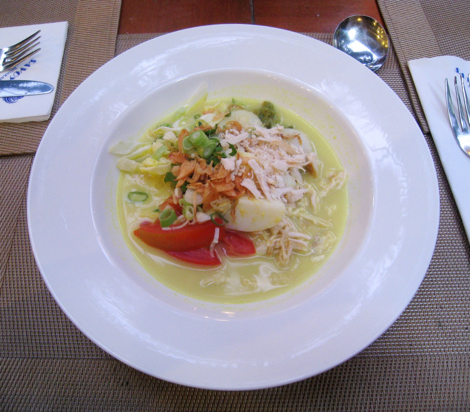 A bowl of soto, golden with turmeric.