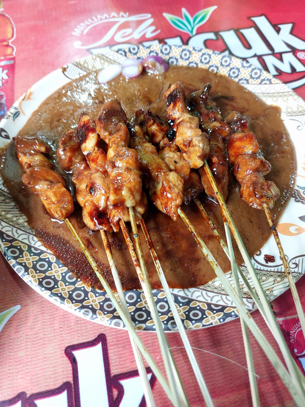Skewers of grilled chicken satay with peanut sauce.