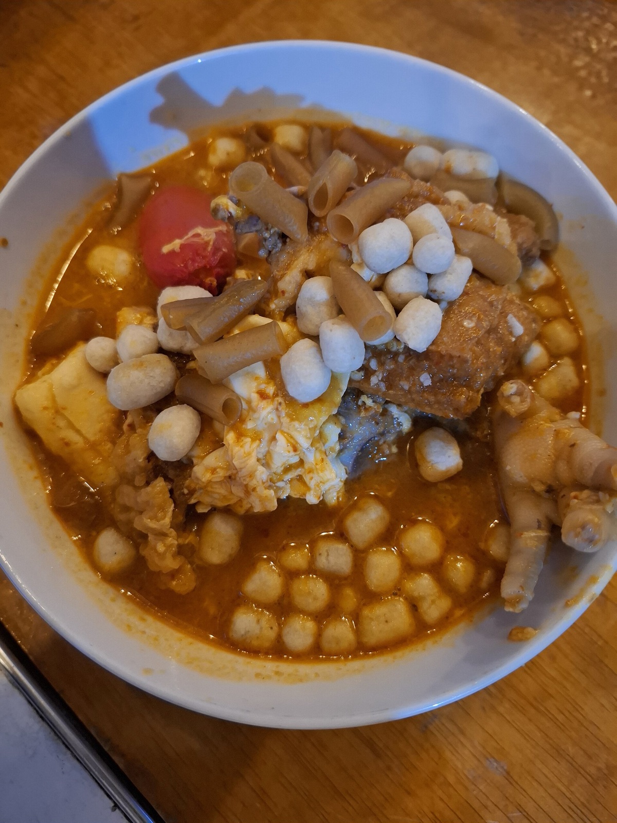 A bowl of seblak with rehydrated crackers, eggs and noodles.